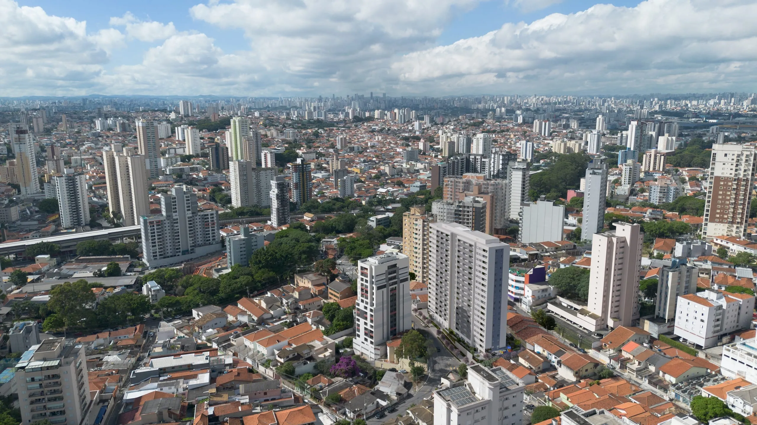 Fotomontagem aérea da vizinhança, com a torre do L1NE Parada Inglesa entre os prédios e casas do entorno.
