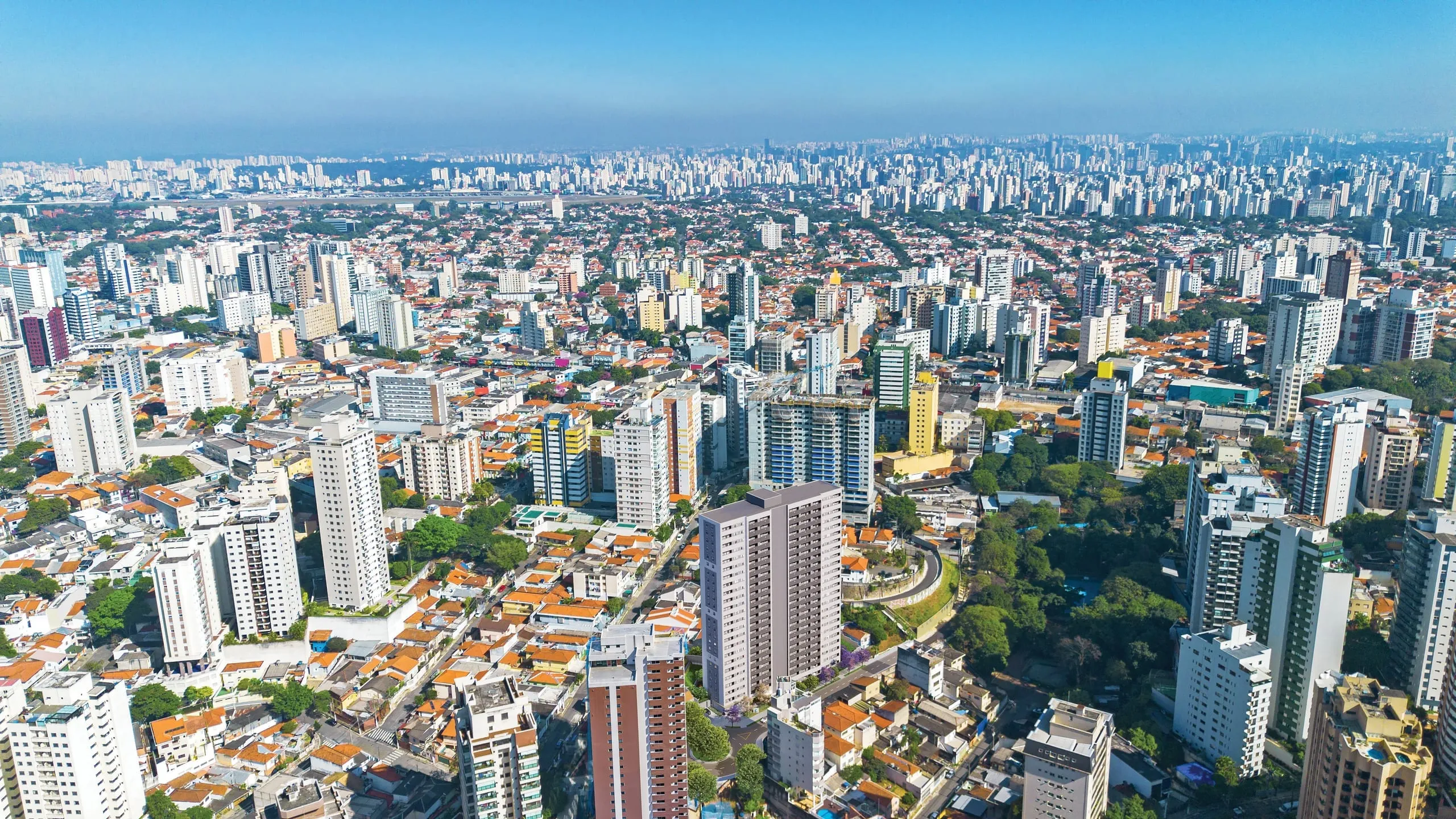Fotomontagem aérea do bairro, com a torre do L1NE Praça da Árvore inserida entre os prédios e as casas do entorno.